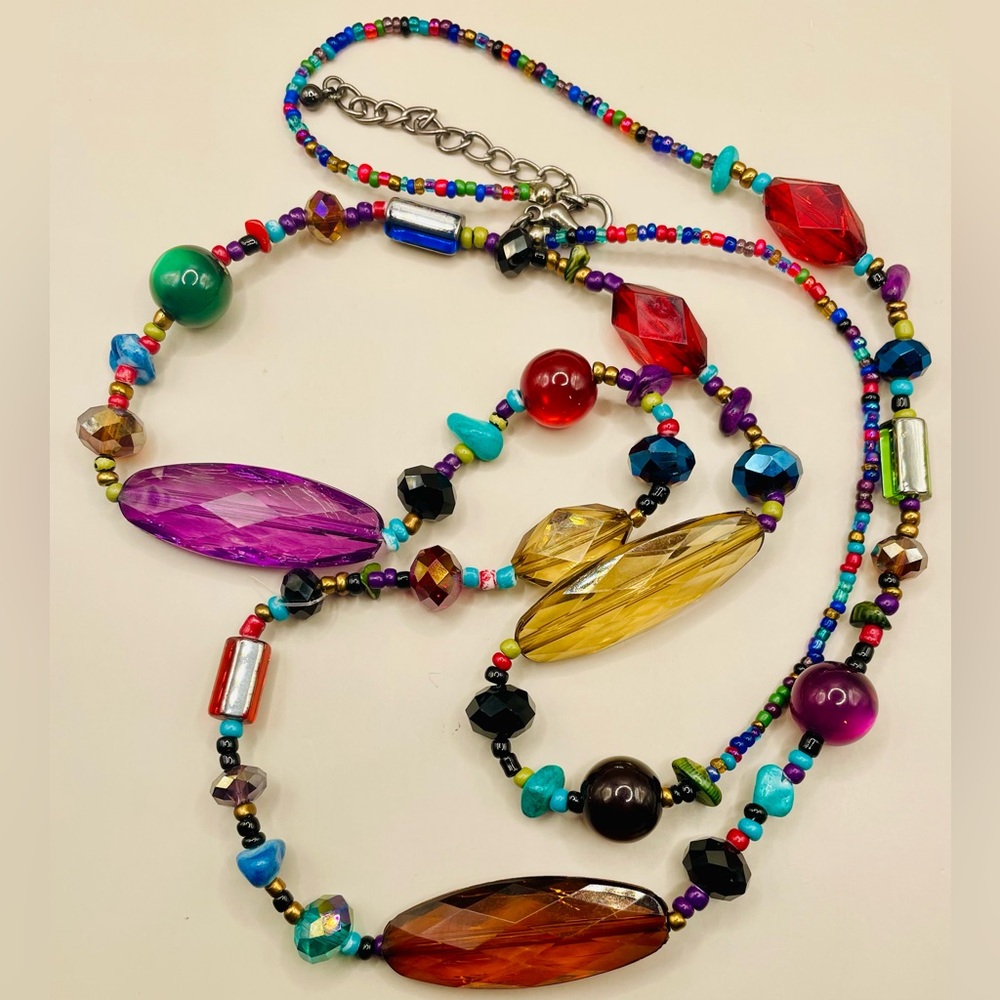 Long jewel tone beaded necklace with various colors and shapes. 36 inches long